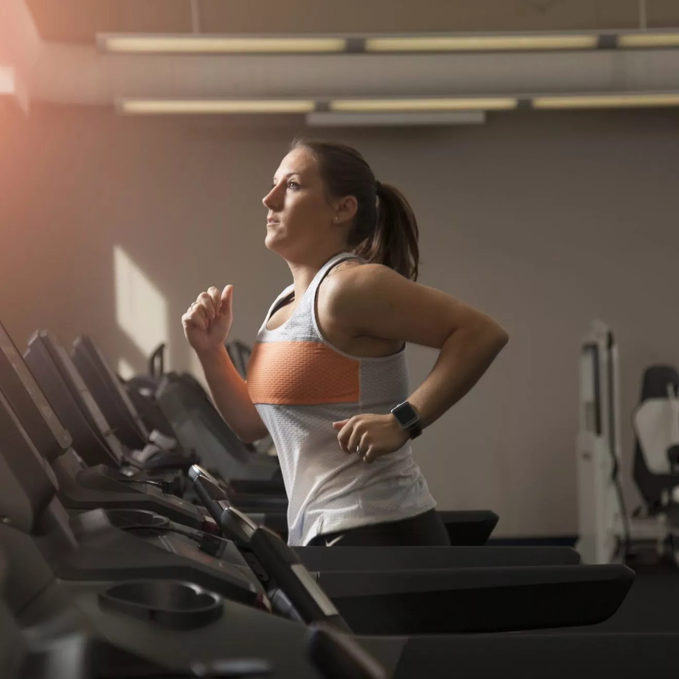 Female running on treadmill doing intervals as workout motivation