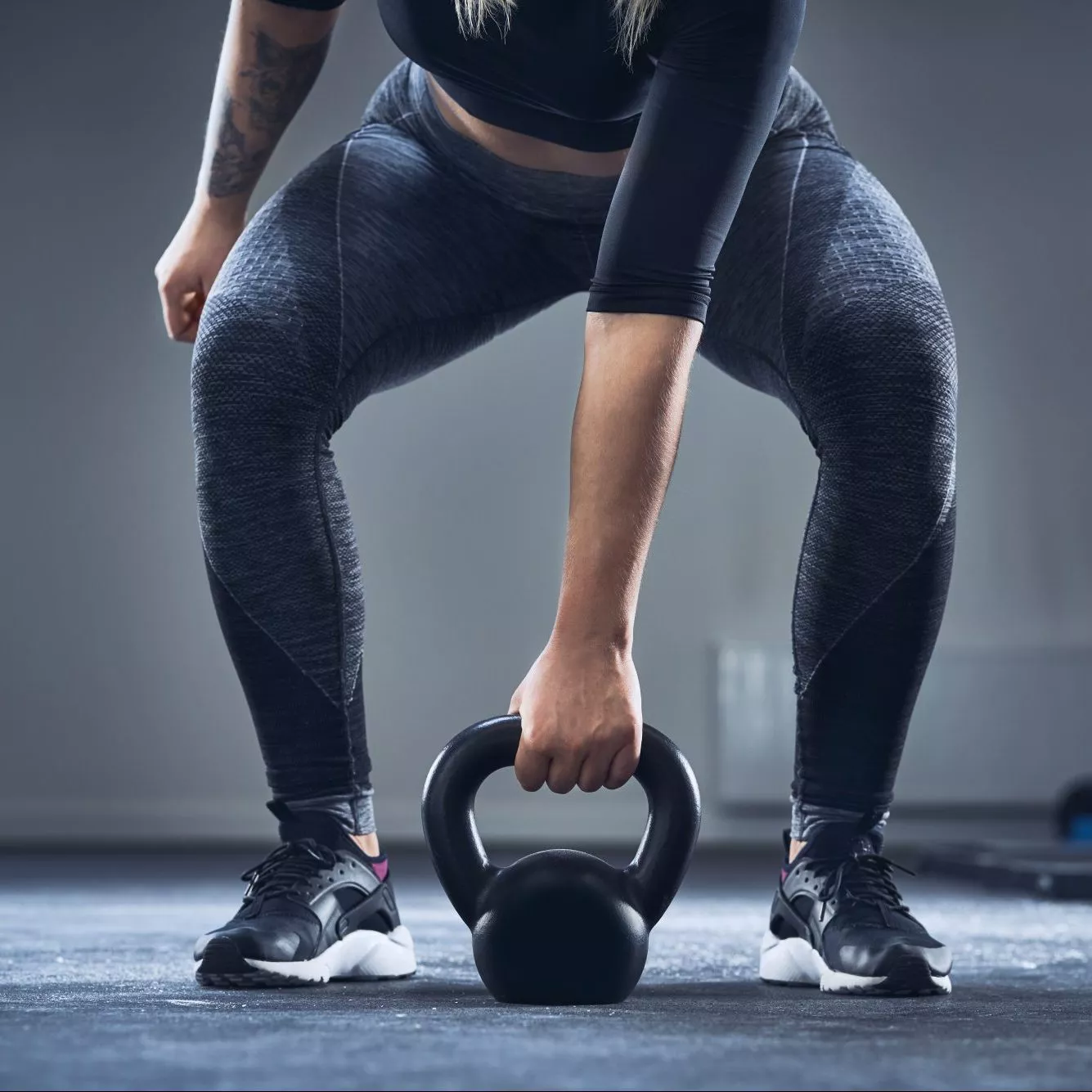Close-up of athletic woman exercising with kettlebell at gym